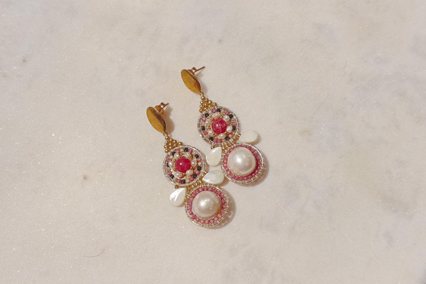 Celebrate a captivating interplay of texture, color, and light with these gold-filled earrings. Luminous freshwater pearls and delicate Keshi pearls offer a touch of timeless elegance. Shimmering strawberry quartz adds a hint of vibrant pink, while delicate mother-of-pearl teardrops boast an iridescent shimmer. Secured on gleaming gold-filled posts, these earrings are a captivating dance of pearl, quartz, and shell.