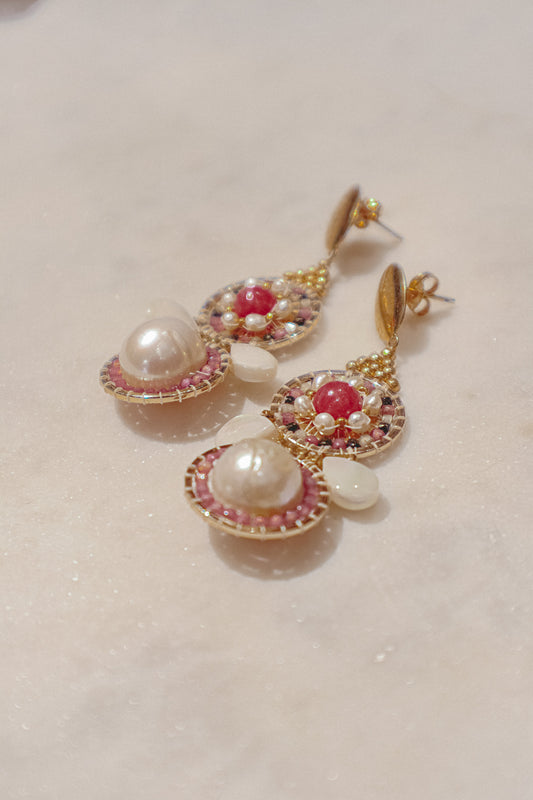 Celebrate a captivating interplay of texture, color, and light with these gold-filled earrings. Luminous freshwater pearls and delicate Keshi pearls offer a touch of timeless elegance. Shimmering strawberry quartz adds a hint of vibrant pink, while delicate mother-of-pearl teardrops boast an iridescent shimmer. Secured on gleaming gold-filled posts, these earrings are a captivating dance of pearl, quartz, and shell.