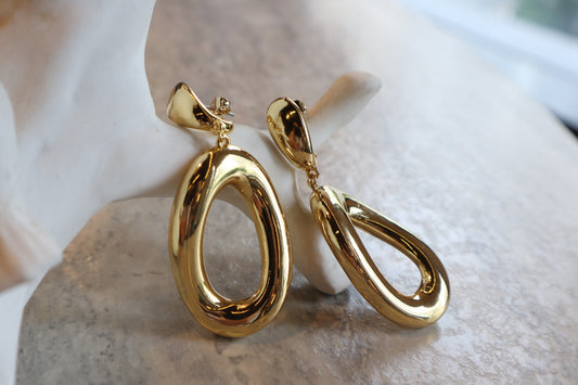 These 18K Gold Filled Thick Distorted Hoop Earrings are a statement piece that will turn heads. The asymmetrical design is both modern and timeless, making them a versatile addition to your jewelry collection.