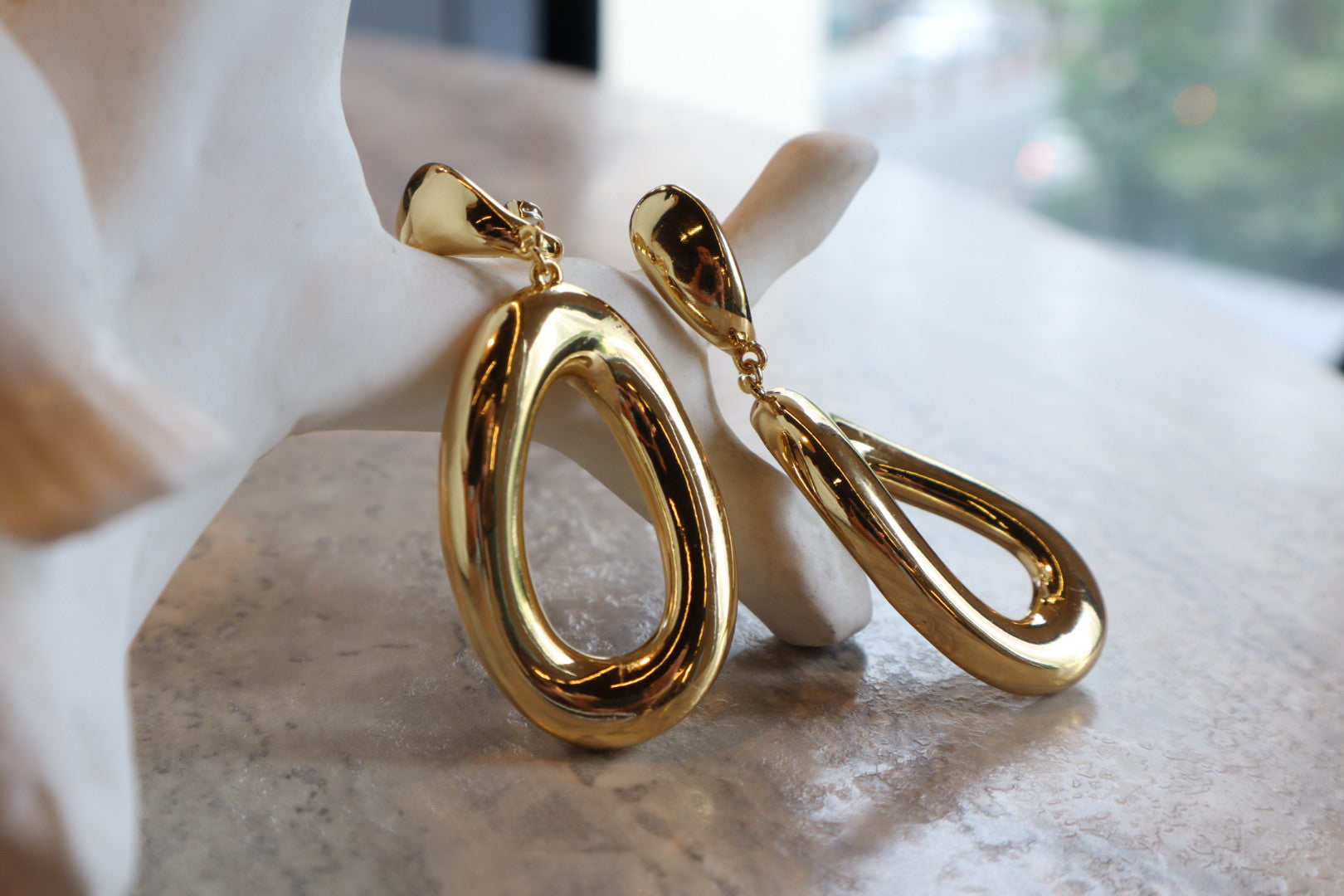 These 18K Gold Filled Thick Distorted Hoop Earrings are a statement piece that will turn heads. The asymmetrical design is both modern and timeless, making them a versatile addition to your jewelry collection.