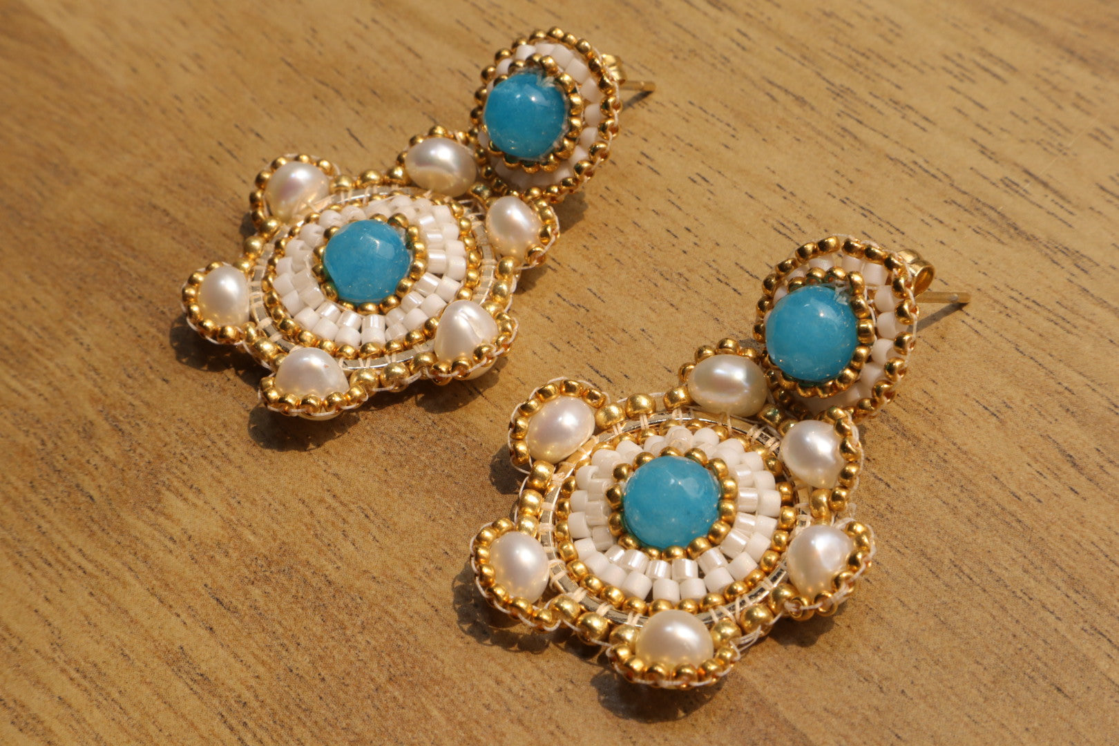 Blue Agate with Fresh Water Pearls on Gold-Filled hardware.  Soothing blue agate stones, reminiscent of cool ocean water, are nestled alongside luminous freshwater pearls. Each element is meticulously crafted in gleaming gold-filled hardware, creating a touch of ocean-inspired elegance for any occasion.