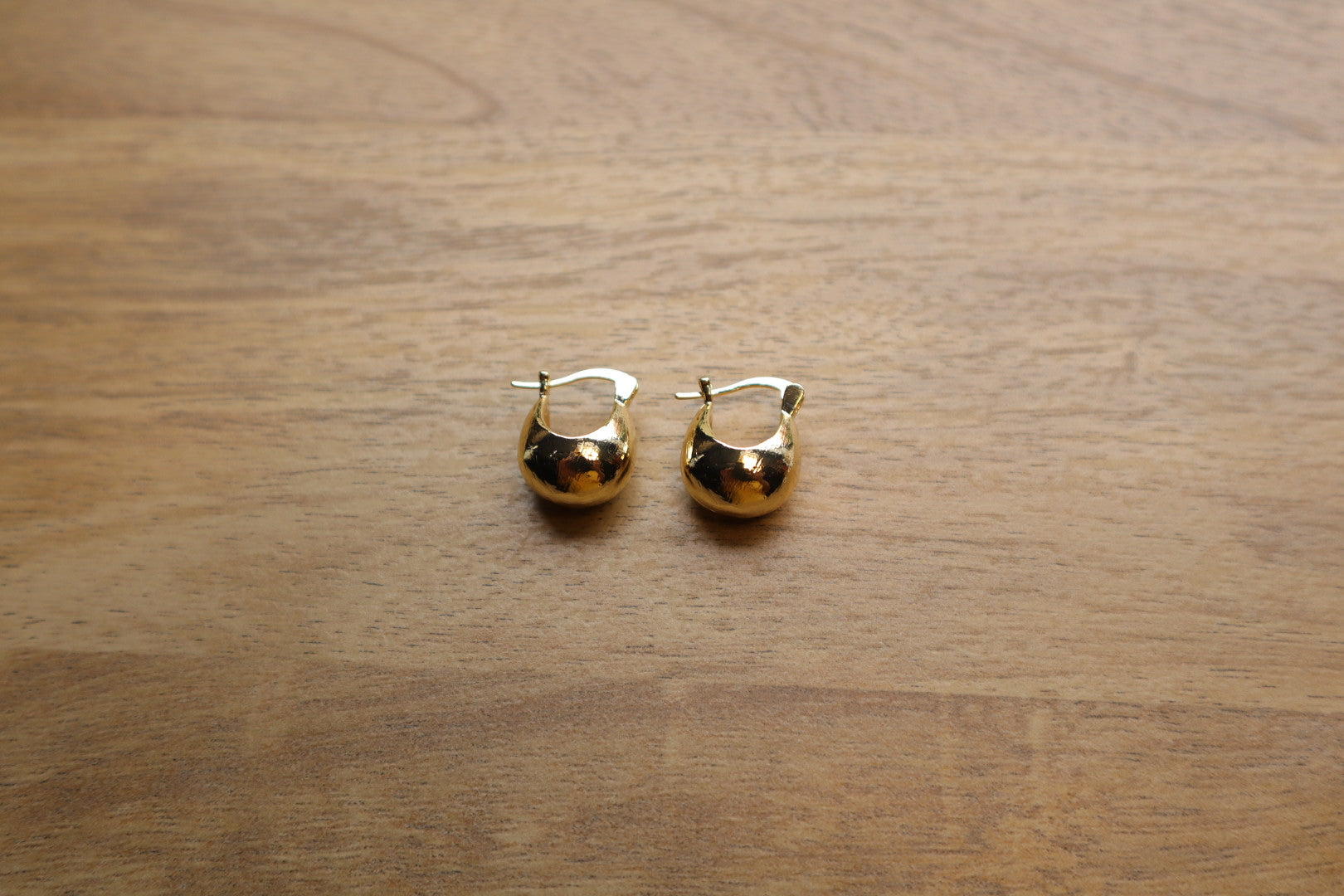 Illuminate your style. Our 18K gold-filled hoop bulb earrings add a touch of playful sophistication.