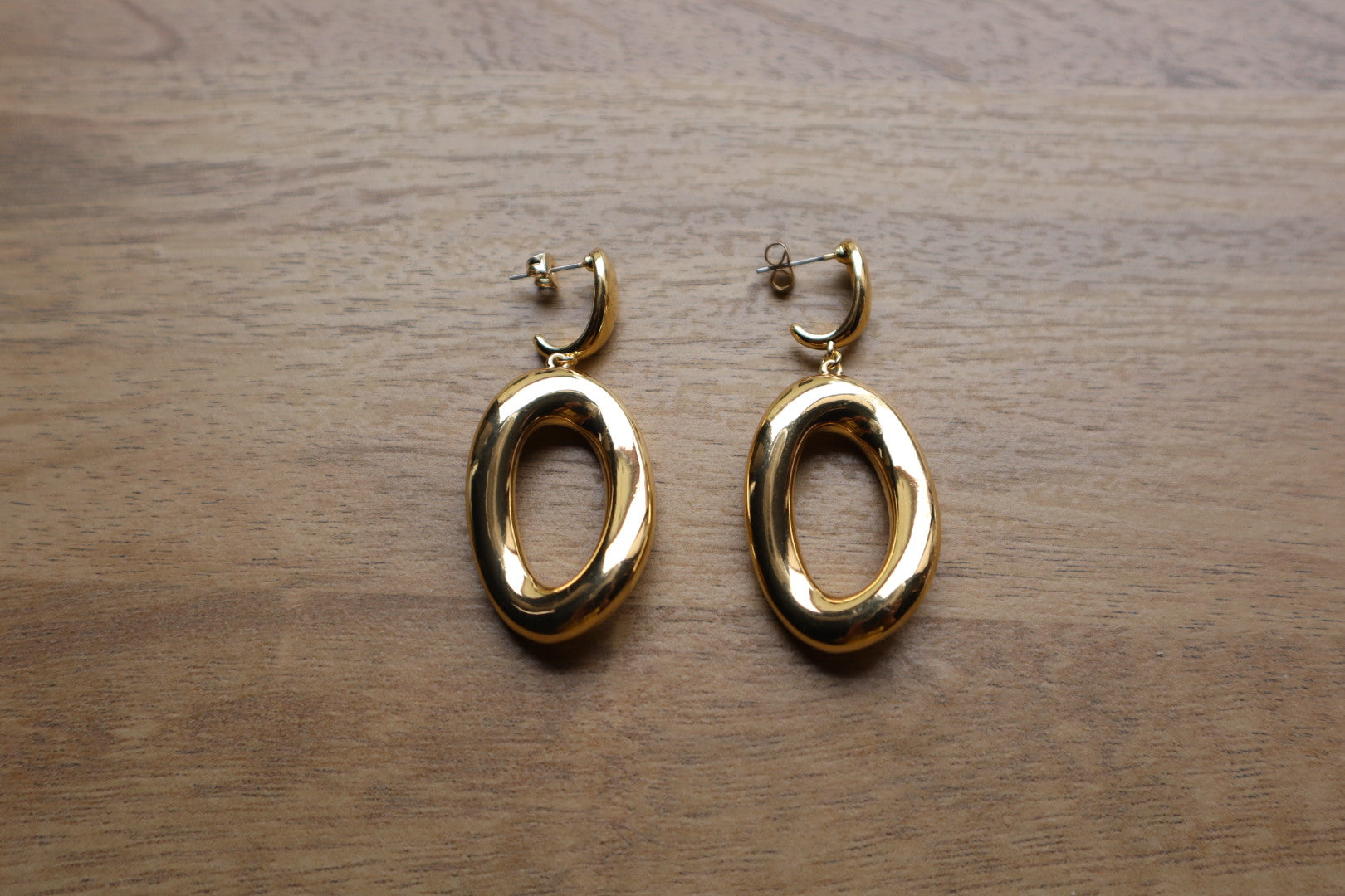 These 18K Gold Filled Thick Distorted Hoop Earrings are a statement piece that will turn heads. The asymmetrical design is both modern and timeless, making them a versatile addition to your jewelry collection.