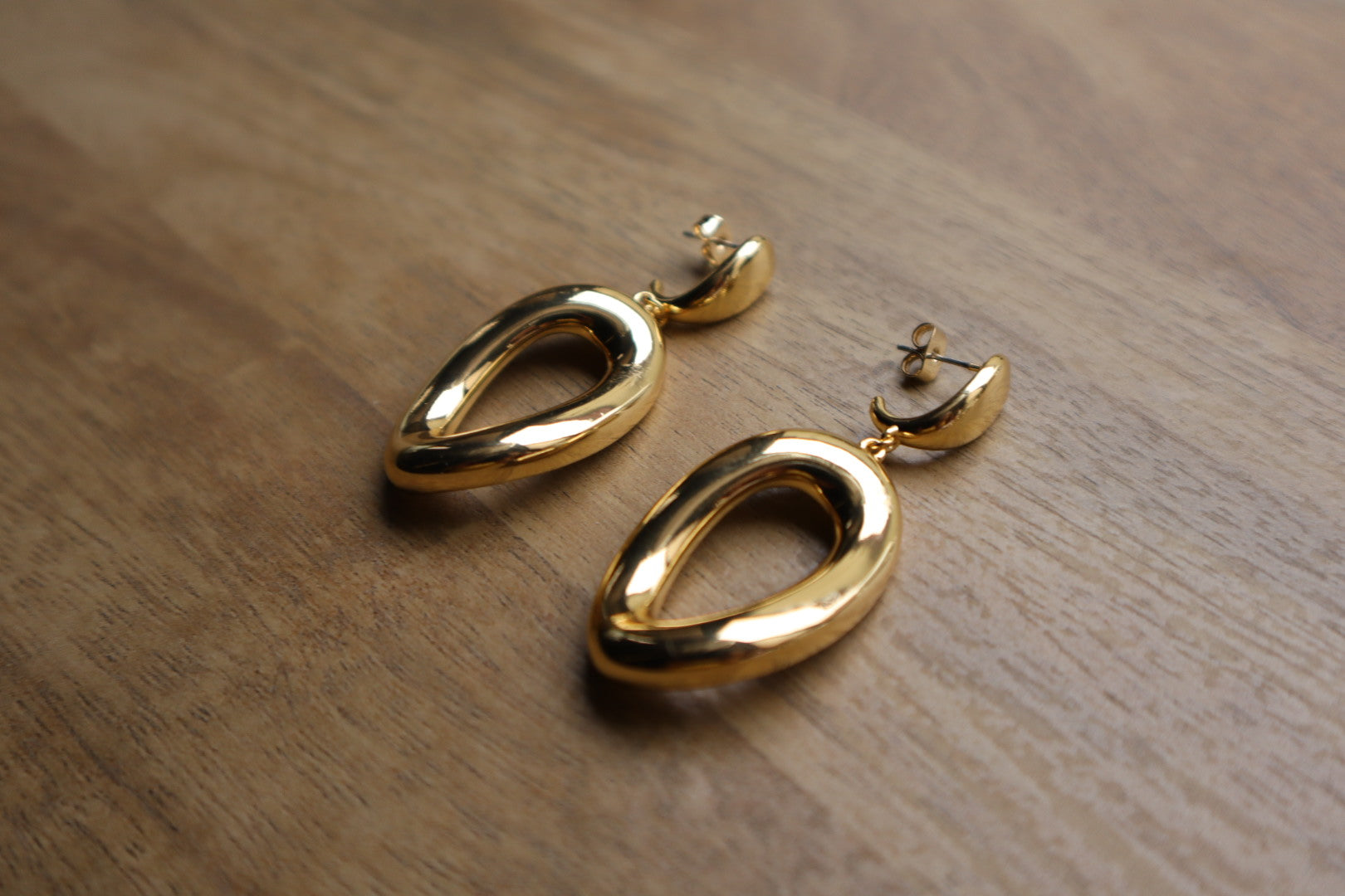 These 18K Gold Filled Thick Distorted Hoop Earrings are a statement piece that will turn heads. The asymmetrical design is both modern and timeless, making them a versatile addition to your jewelry collection.