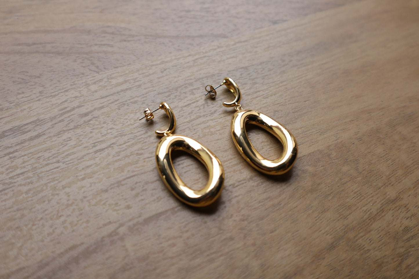 These 18K Gold Filled Thick Distorted Hoop Earrings are a statement piece that will turn heads. The asymmetrical design is both modern and timeless, making them a versatile addition to your jewelry collection.
