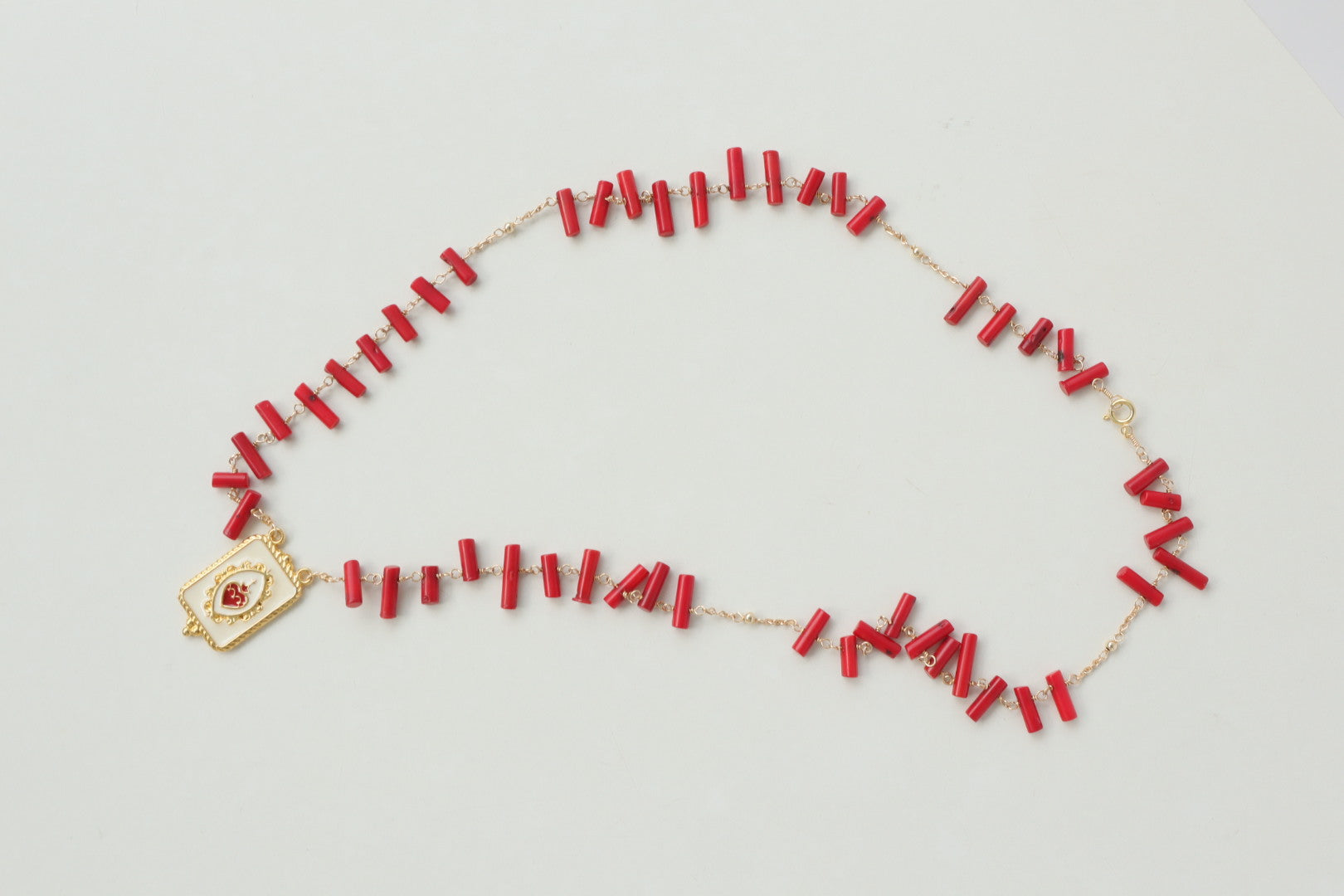 Vibrant coral beads, a touch of the sea, dance on a delicate gold-filled chain, accented by a captivating gold-filled enamel pendant.