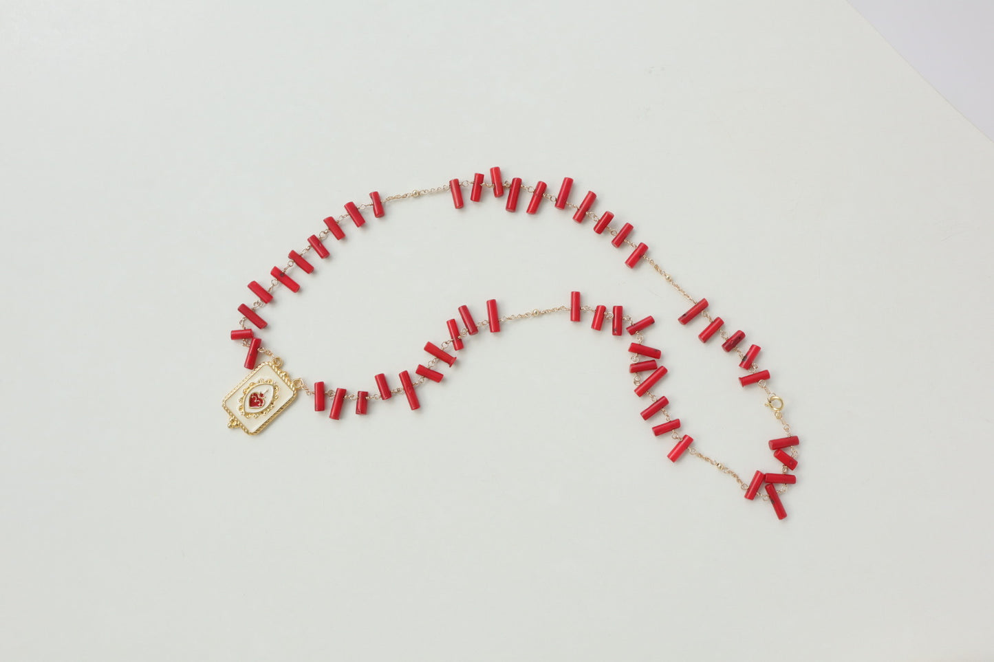 Vibrant coral beads, a touch of the sea, dance on a delicate gold-filled chain, accented by a captivating gold-filled enamel pendant.