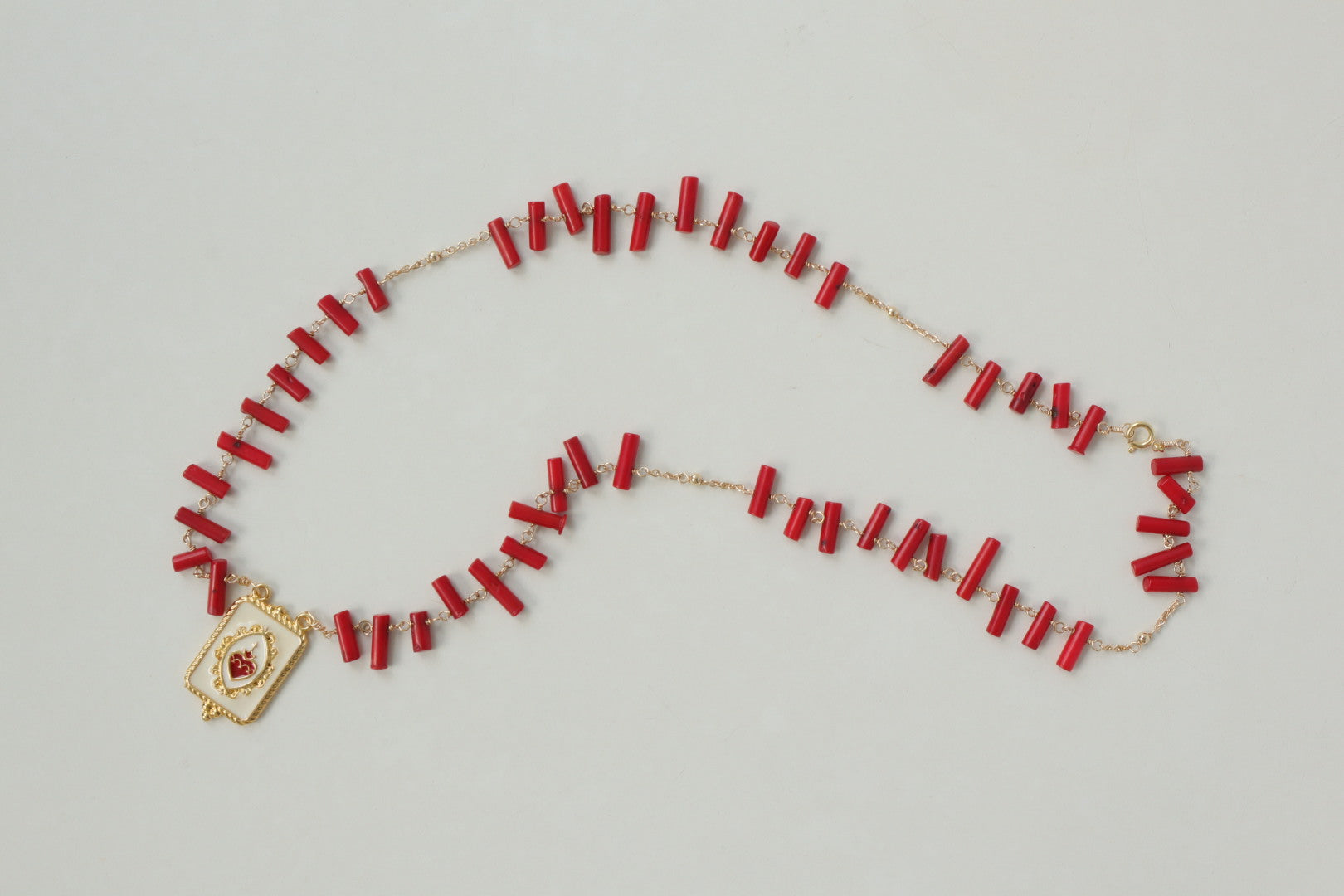 Vibrant coral beads, a touch of the sea, dance on a delicate gold-filled chain, accented by a captivating gold-filled enamel pendant.