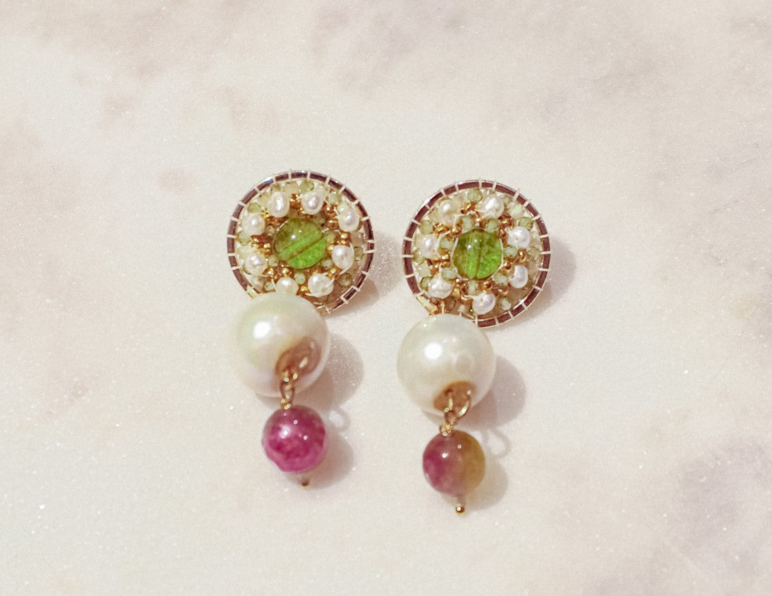 Celebrate a captivating interplay of gem and pearl with these 18k gold-filled earrings. Luminous peridot gemstones boast a refreshing lime green hue, symbolizing growth and prosperity. Tourmaline gemstones add a touch of vibrant color, mixing hues of deep pink to bright red. Organic baroque pearls whisper of elegance, while Keishi pearls add a touch of unique beauty. Secured on gleaming 18k gold-filled posts, these earrings are a captivating dance of texture, light, and symbolism.