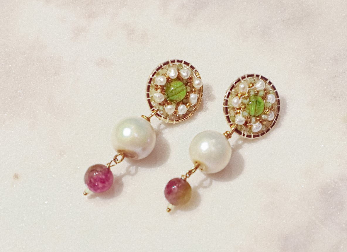 Celebrate a captivating interplay of gem and pearl with these 18k gold-filled earrings. Luminous peridot gemstones boast a refreshing lime green hue, symbolizing growth and prosperity. Tourmaline gemstones add a touch of vibrant color, mixing hues of deep pink to bright red. Organic baroque pearls whisper of elegance, while Keishi pearls add a touch of unique beauty. Secured on gleaming 18k gold-filled posts, these earrings are a captivating dance of texture, light, and symbolism.