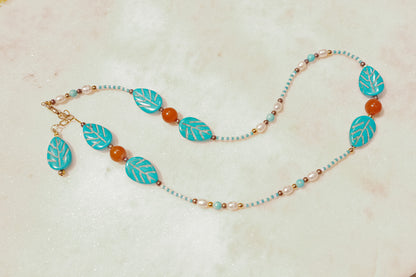 A symphony of the sea. Luminous pearls, shimmering mother-of-pearl, vibrant turquoise, and pops of coral dance on a gold-filled chain on this choker necklace.