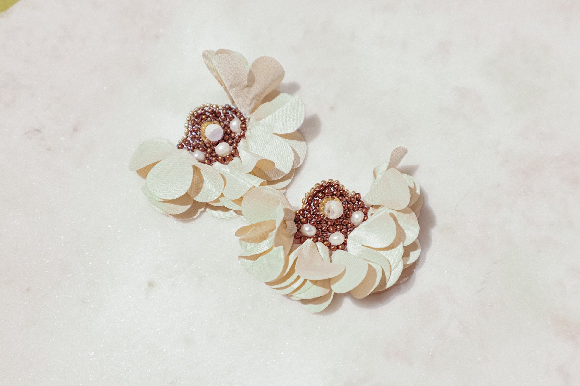 Introducing our exquisite floral earrings, crafted with meticulous attention to detail. Each pair features delicate fabric flowers adorned with lustrous freshwater pearls, complemented by a gold-plated stainless steel post. Elevate your elegance with this timeless accessory, perfect for any discerning jewelry connoisseur.