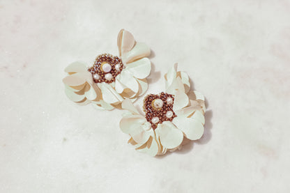 Introducing our exquisite floral earrings, crafted with meticulous attention to detail. Each pair features delicate fabric flowers adorned with lustrous freshwater pearls, complemented by a gold-plated stainless steel post. Elevate your elegance with this timeless accessory, perfect for any discerning jewelry connoisseur.