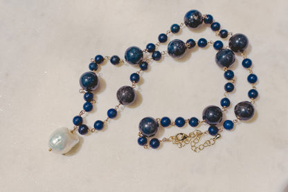 Rich lapis lazuli beads, a touch of the sea and sky, dance on a gleaming gold-filled wire chain. A luminous baroque pearl takes center stage, creating this statement piece necklace of simple beauty.