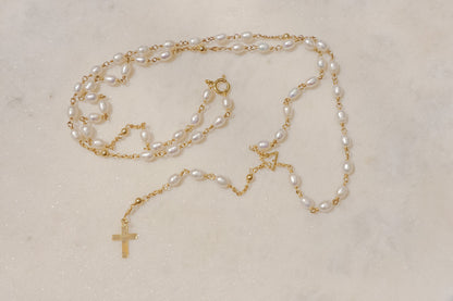 Luminous pearls, timeless symbols of purity and faith, adorn a delicate gold-filled wire chain.