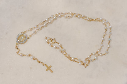 Luminous pearls, symbolic of purity and wisdom, adorn a delicate chain, culminating in a radiant CZ Mother Mary pendant. A beautiful companion for moments of reflection and connection with your inner light and divine guidance.