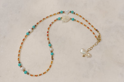 A symphony of the sea. Luminous pearls, shimmering mother-of-pearl, vibrant turquoise, and pops of coral dance on a gold-filled chain.