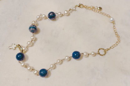 Embrace timeless elegance with a touch of bold beauty. This captivating gold-filled necklace features luminous pearls, a symbol of classic sophistication. The deep blue hues of the lapis lazuli gemstones add a touch of intrigue and depth, creating a perfect harmony. Secured on a delicate gold-filled chain, this necklace is a versatile piece that can elevate any outfit.