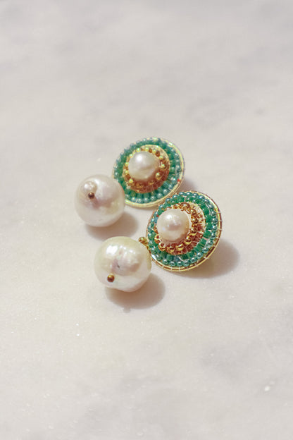 These earrings showcase a captivating interplay of classic and modern design. Luminous pearl drops exude timeless elegance, while shimmering green Miyuki beads, meticulously woven around the posts, add a touch of modern flair. Secured on gleaming 18k gold-filled posts, these earrings are perfect for everyday wear or a touch of elegance for a special occasion