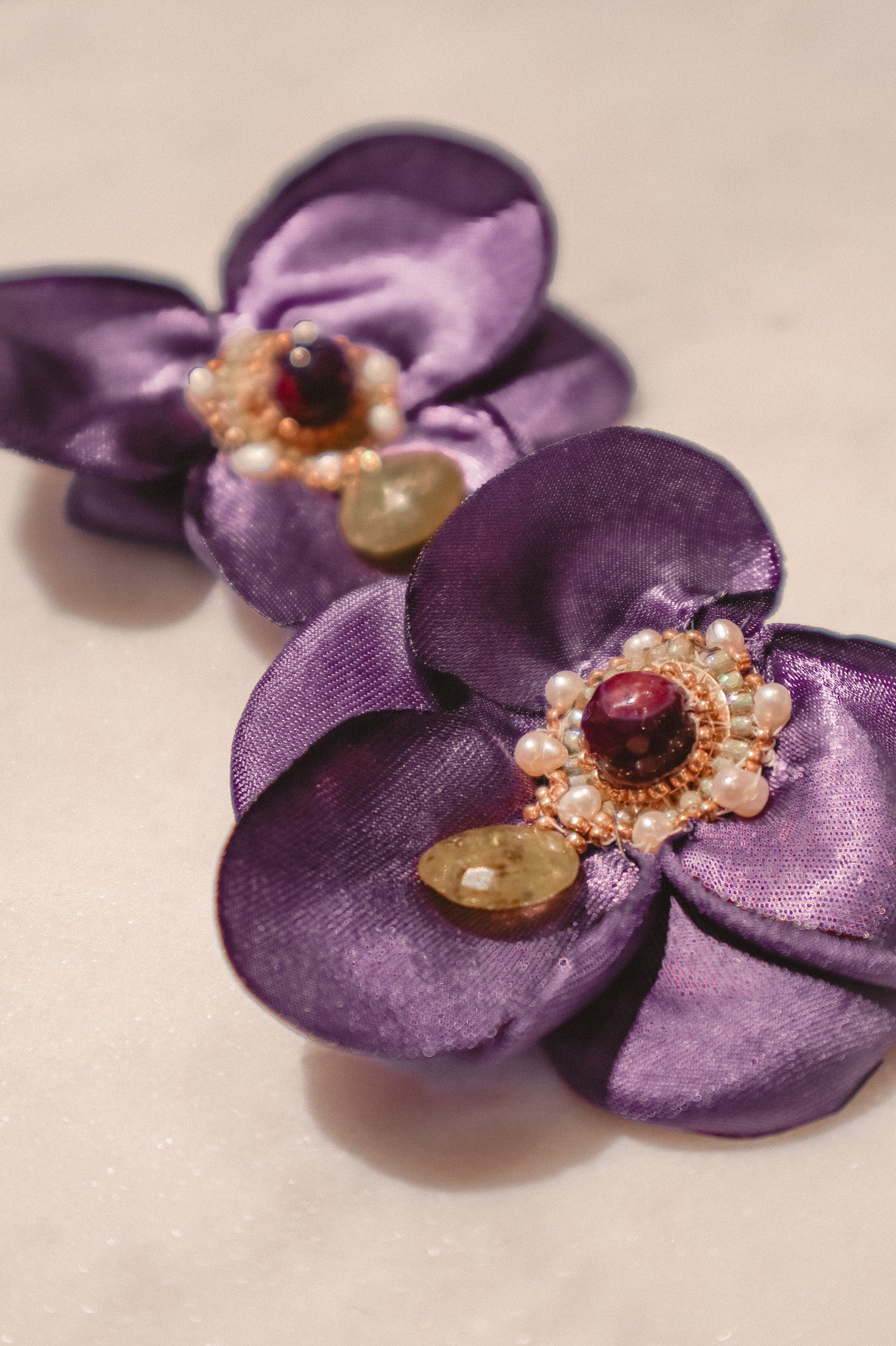 Deep purple silk blend petals provide a luxurious backdrop for a mesmerizing display of gemstones on these Flower Fan earrings. Agate and Vessonite drops boast captivating colors and textures, while delicate Keshi pearls add a touch of organic elegance. Secured on gleaming gold-filled findings, these earrings are a symphony of color and texture, a true conversation starter.